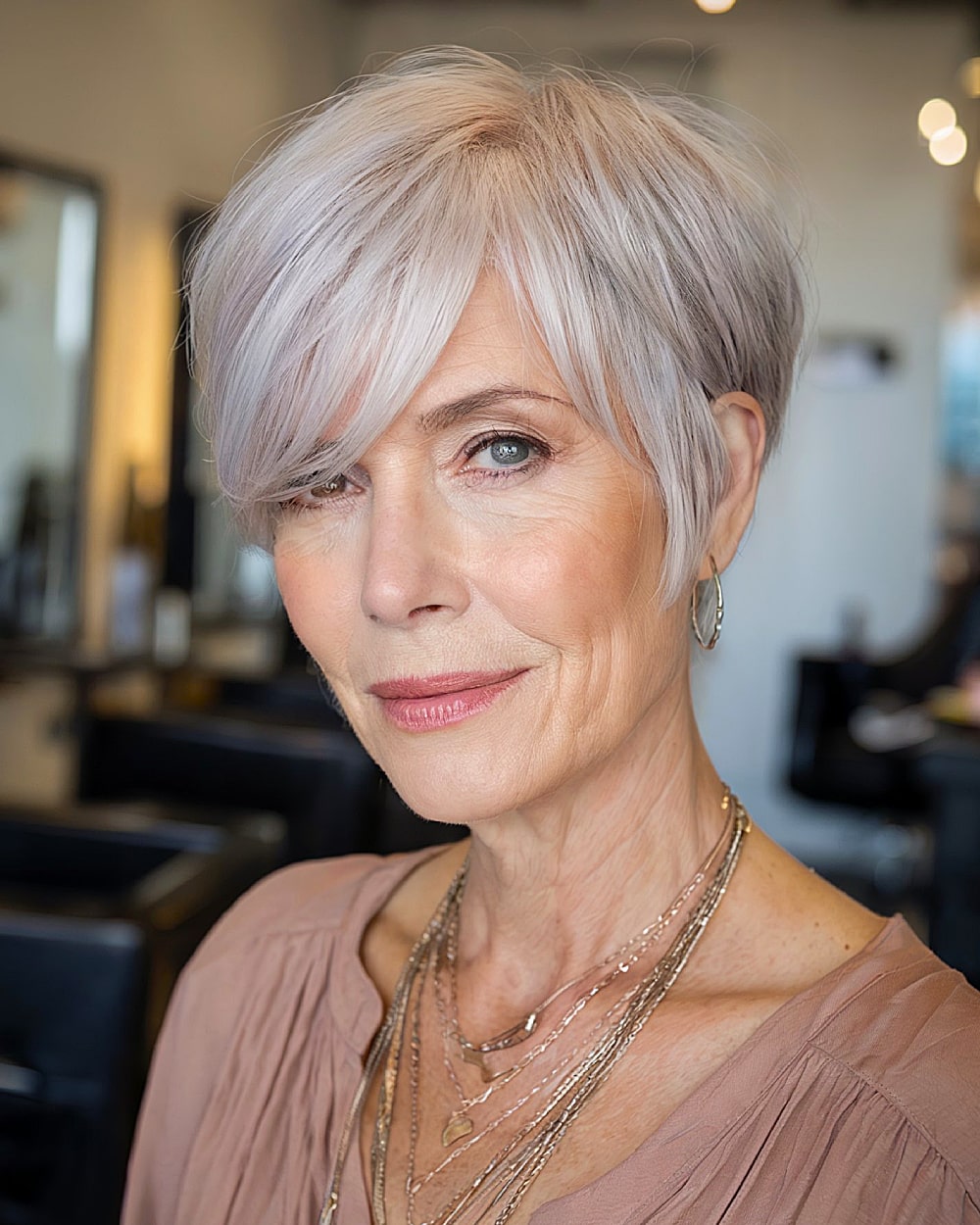 Tapered long pixie with side-swept fringe and soft lavender-blonde tones for women over 60