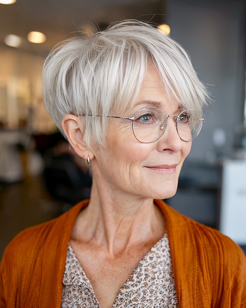Wispy pixie cut with long bangs and lightweight layering for women over 60 with glasses