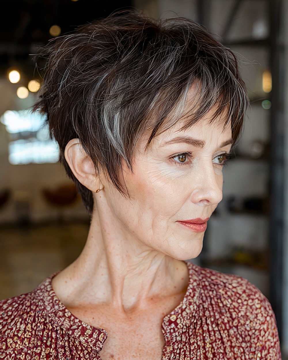 Choppy textured long pixie with piece-y layers and natural dark base for women over 60
