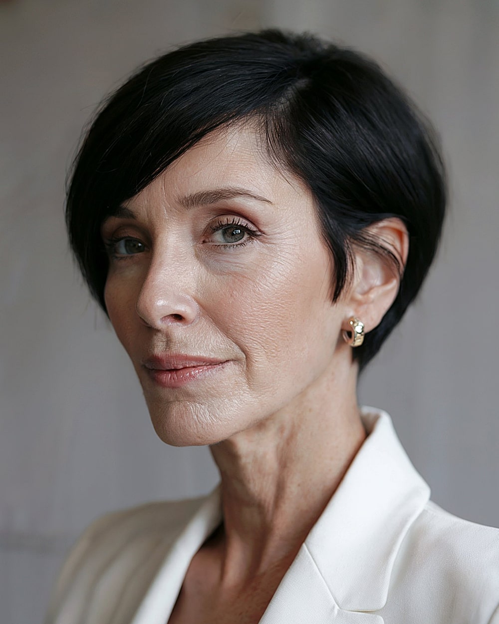 Snib bob haircut with jet-black color and sharp side part for older women