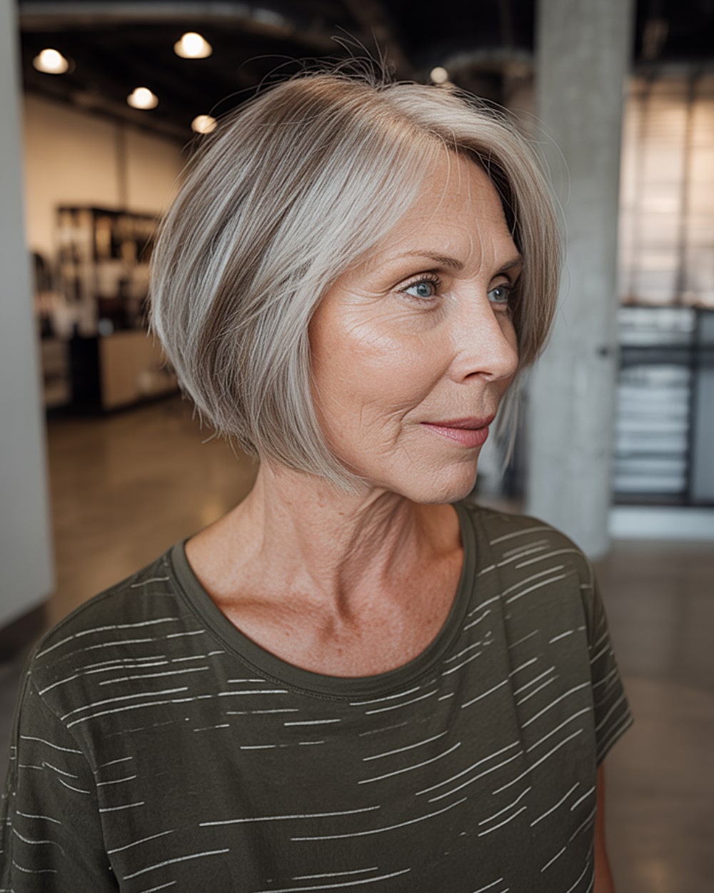 Short 60+ angled bob with sleek silver hair and layers stacked in the back