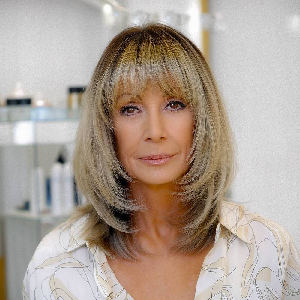 Medium length haircut with soft bangs, a soft and feminine look for women over the age of sixty