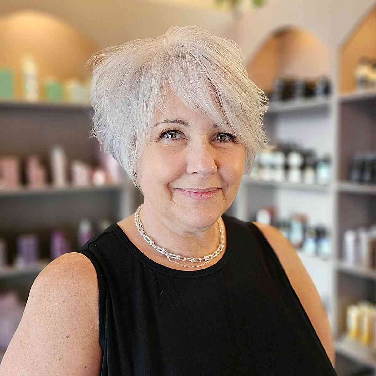 Tight white pixie with side bangs for women over 60