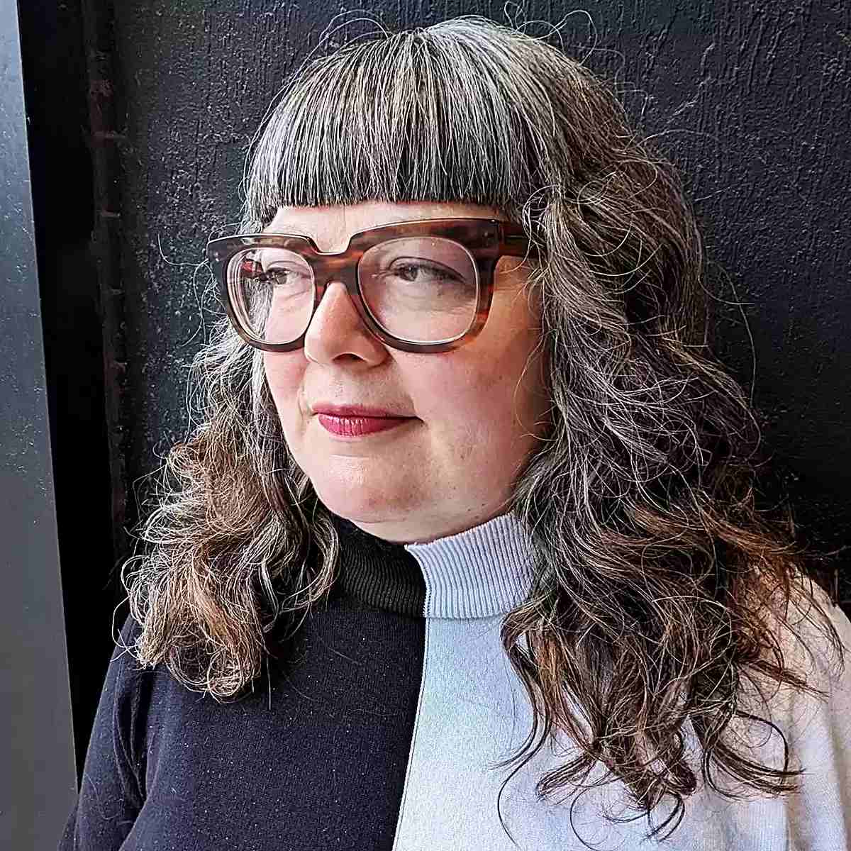 Messy wavy hair with blunt bangs for older women over 60