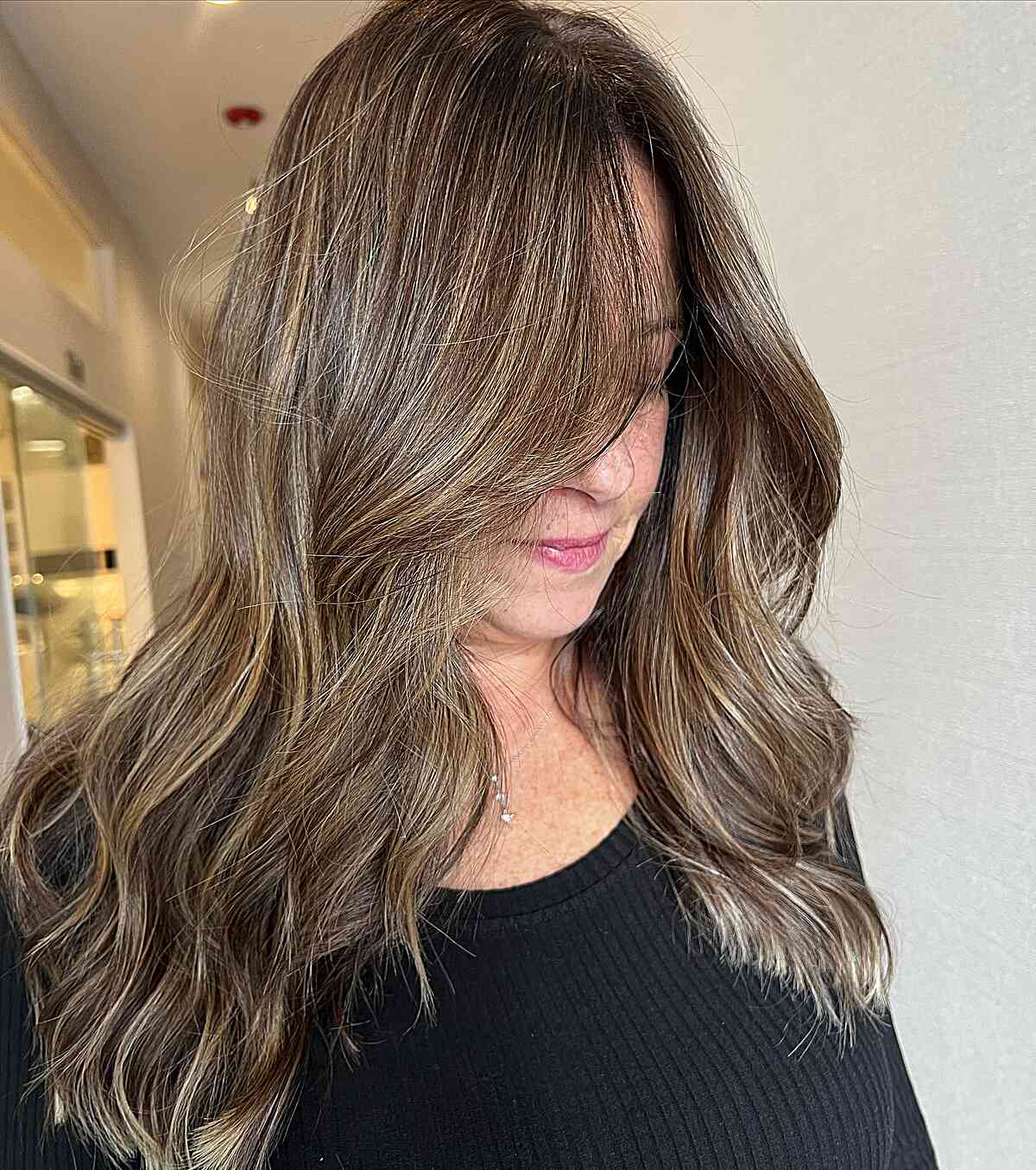 Dimensional golden brunette with long waves for 60 year old women
