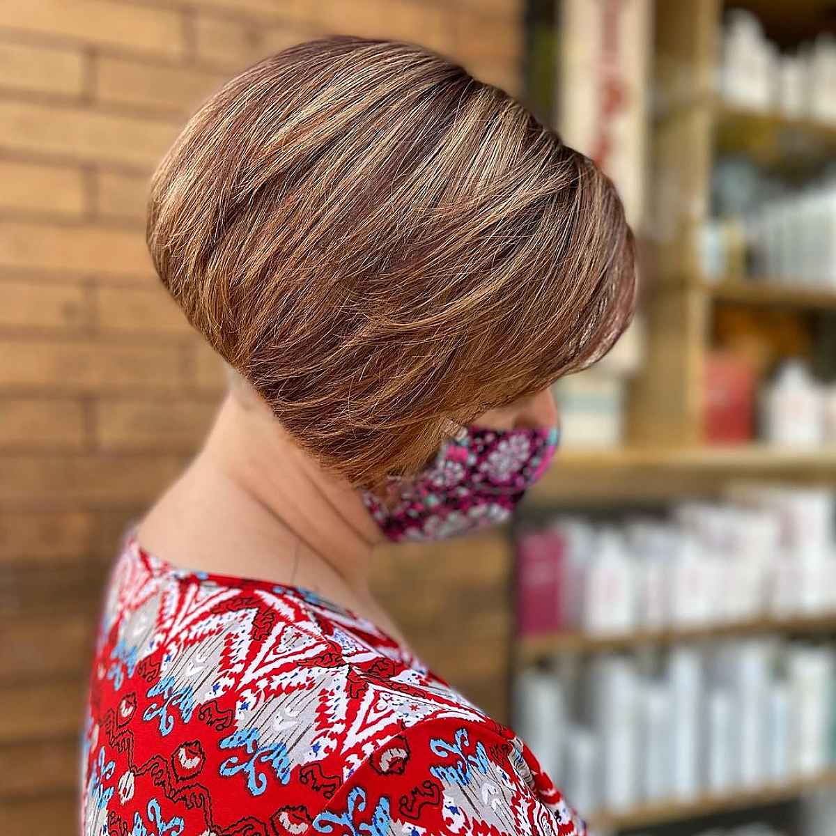 A short, inverted bob with touches of auburn and caramel