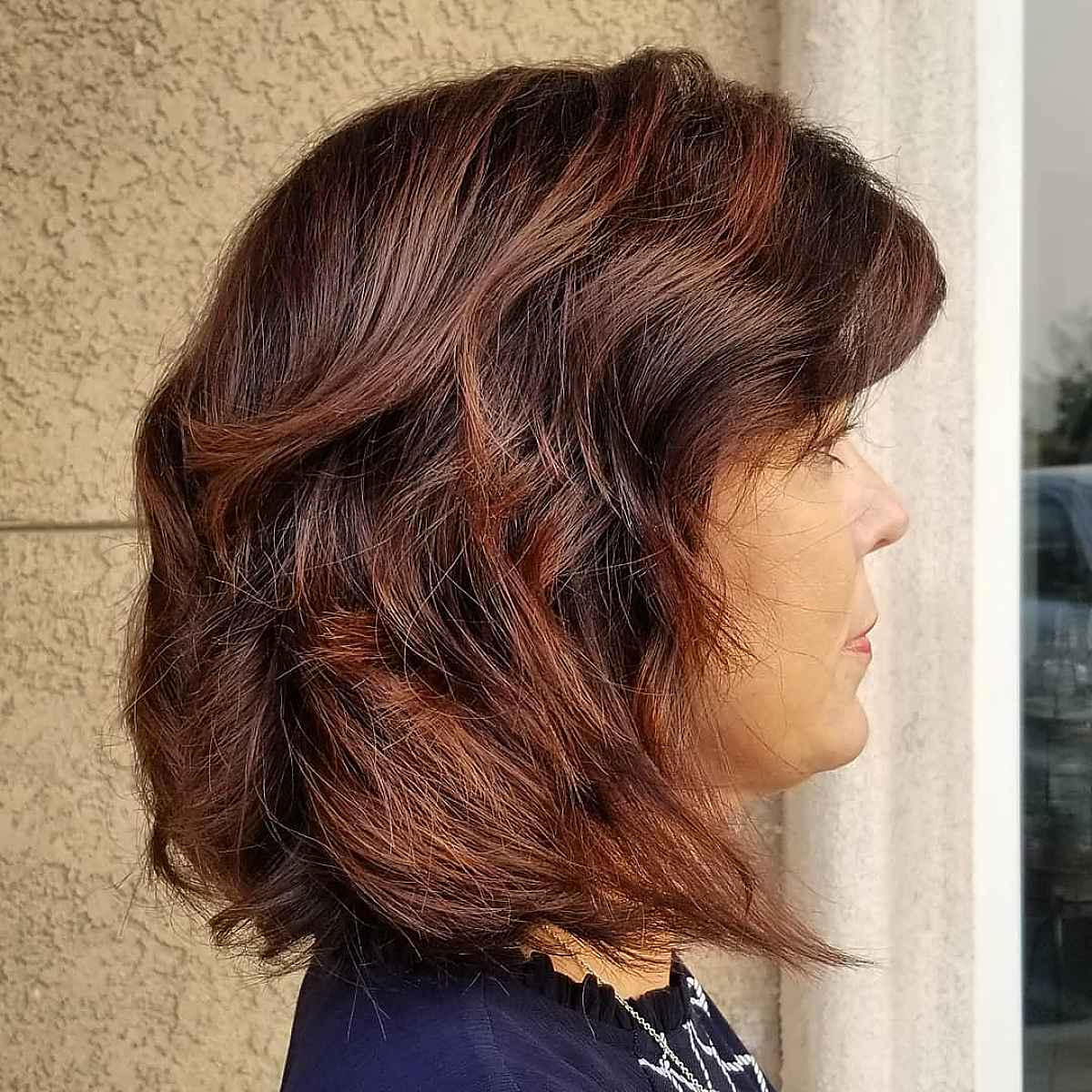 Long bob hairstyle with rich burgundy highlights