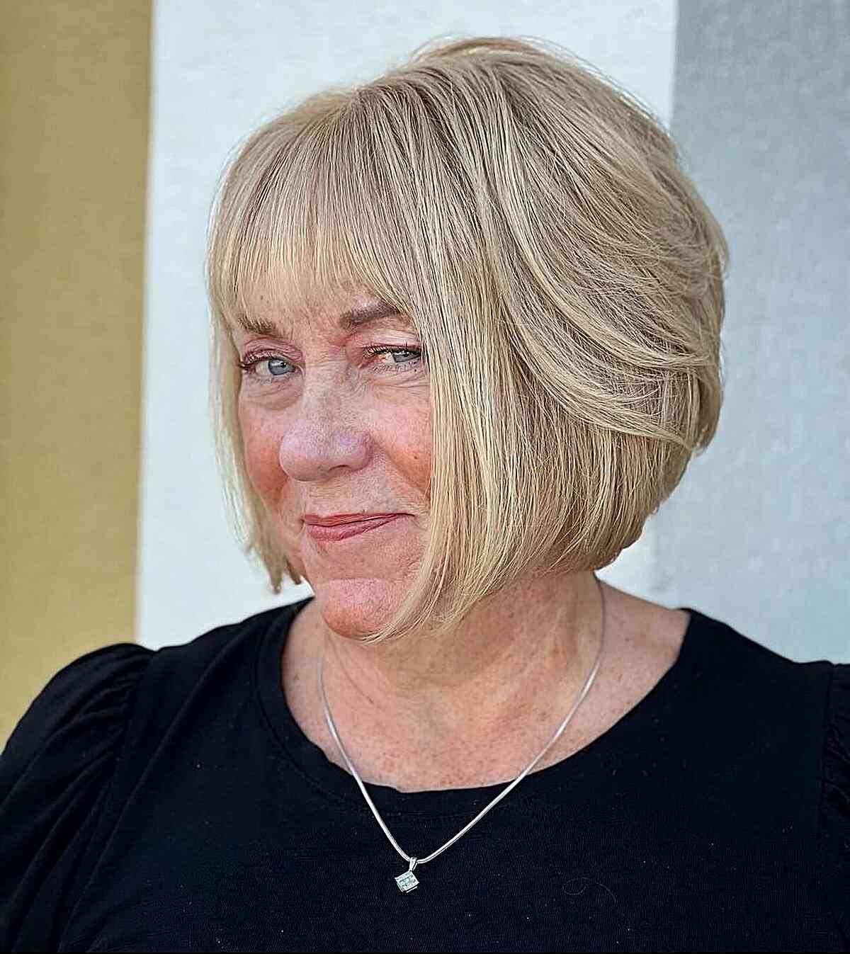 A short, thick, face-framing angular bob with layers for older ladies over 60